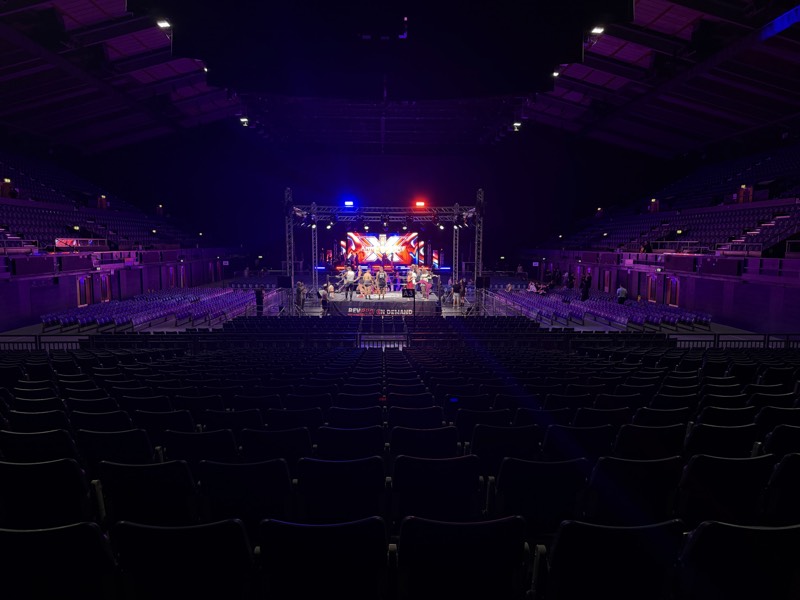 Arena stage with an LED backdrop under a lighting rig