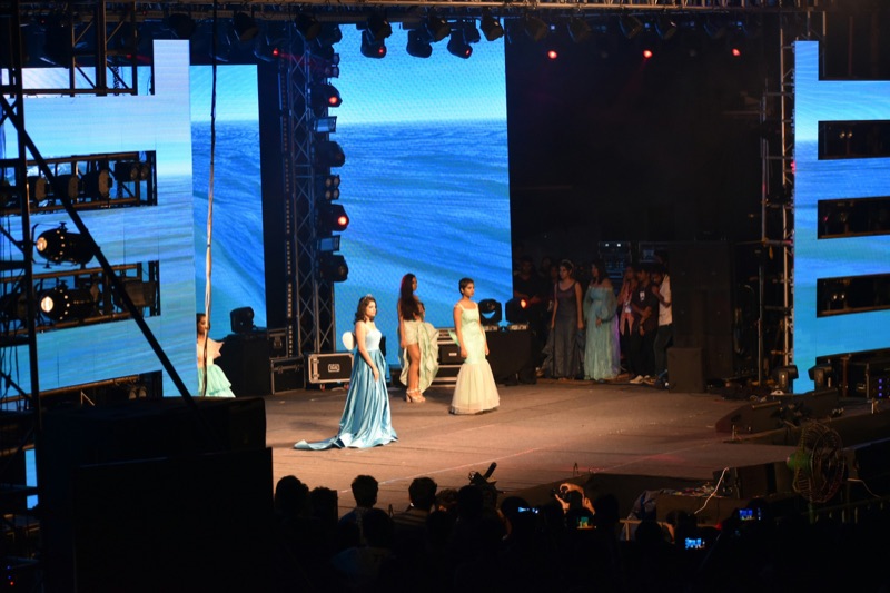 Example image: an outdoor catwalk stage with a large video wall behind the models