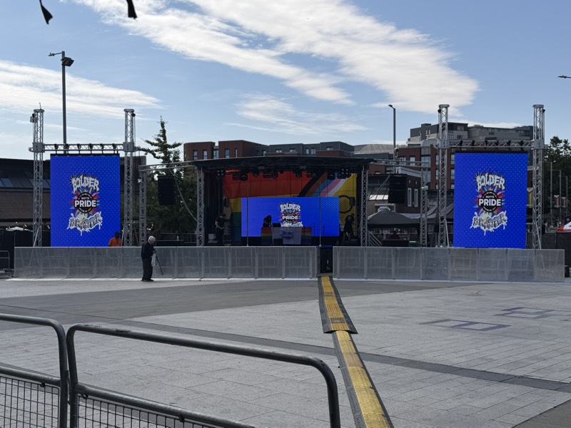 Outdoor Pride festival stage with two LED screens on truss towers