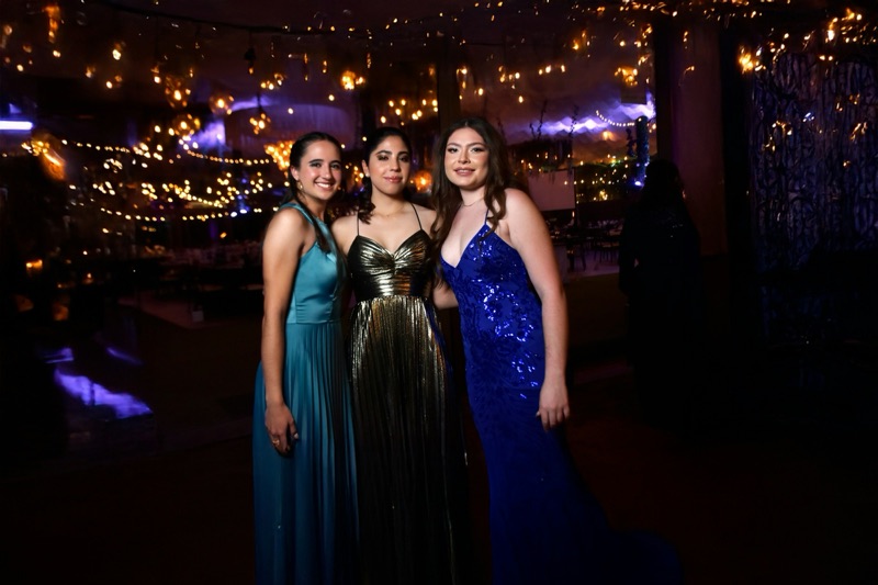 Example image: students in prom gowns under festoon lights and uplighting