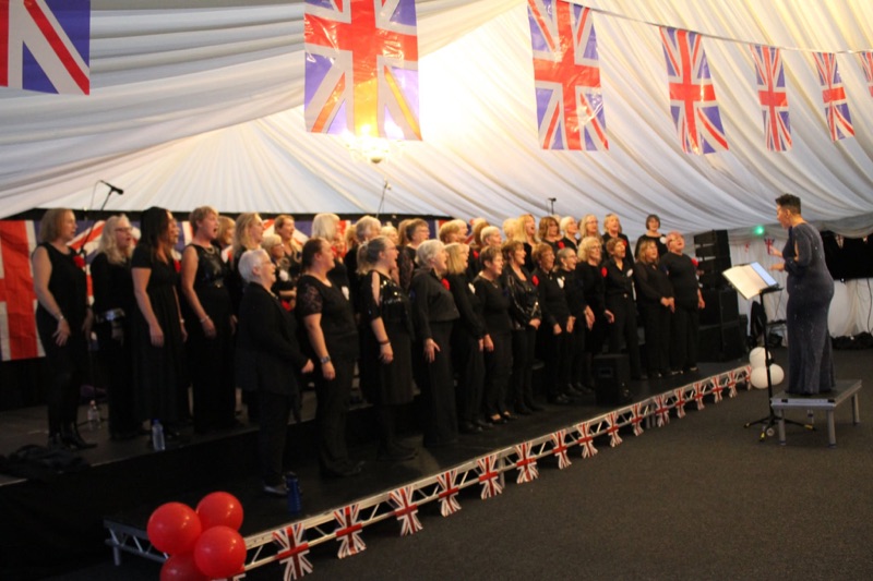 Forest Pop Choir singing on the Pixel 8 stage in the marquee at Proms on the Pitch, Mansfield Town FC