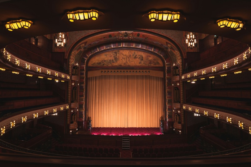 Grand theatre auditorium with balconies and house lights