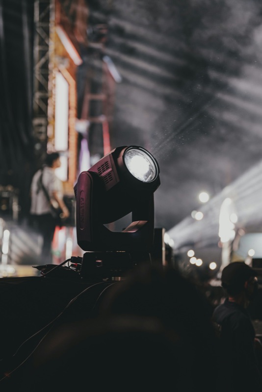 Moving-head stage light above an audience