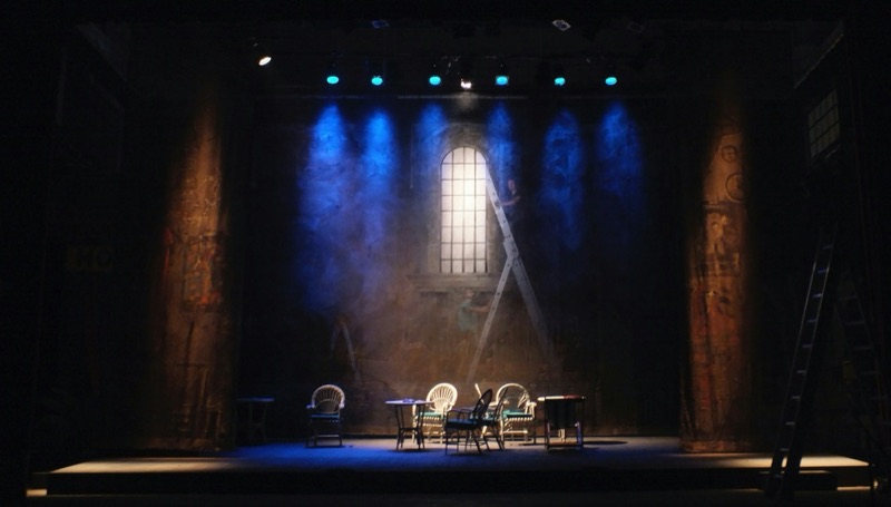 Theatre stage set lit with blue spotlights and haze
